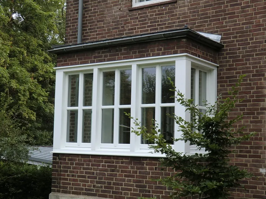 Weiße Holzfenster in einem mehrseitigen Erker